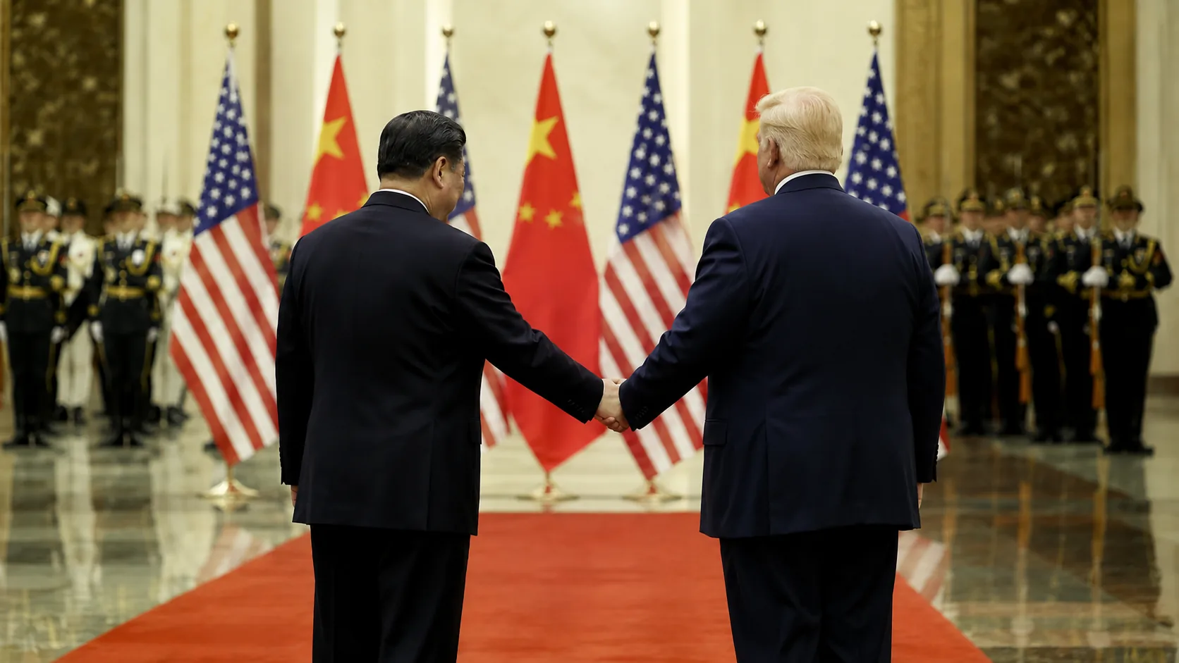 Two heads of state shaking hands on a red carpet in front of crossed United States and Chinese flags, an honor guard behind them — visual metaphor for President Trump's May 13–15, 2026 state visit to Beijing and his summit with Xi Jinping.